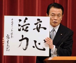 年頭会見で、自ら書いた色紙を報道陣に披露する麻生太郎首相。