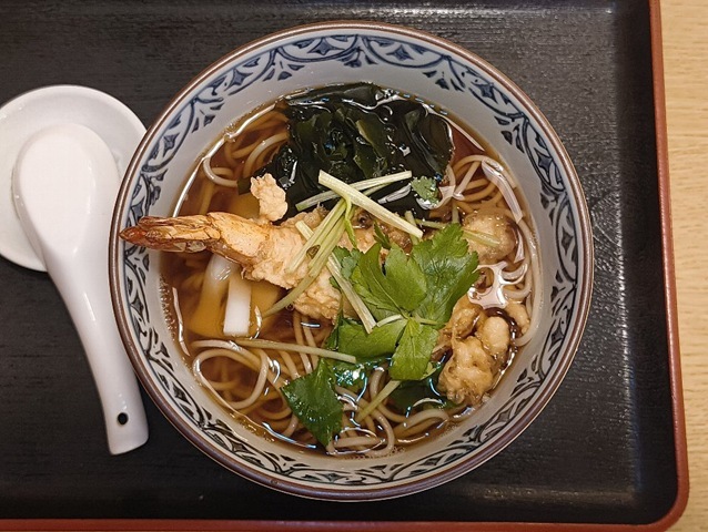 『琴富貴』の「天ぷらそば」（並）でランチ。衣が今にもバラバラになりそうな絶妙な塩梅になってくる。その衣をガブリとやり、天ぷらの油が溶け出した汁を蕎麦に絡めて一気に手繰る。言うまでもなく、最高にうまいのだよ（笑）。（琴富貴：墨田区吾妻橋1）