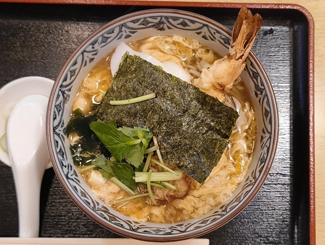 『琴富貴』の「天とじそば」でランチ。丼の中は「たまごとじ」と「海老天」による、過剰なまでの「黄色」に支配されて、 白い「かまぼこ」と黒い「海苔」は、あくまでも名脇役。このハイブリッドな味わいこそが「天とじそば」の要と云爾。勿論、 うまいのだよ（笑）。（琴富貴：墨田区吾妻橋1）