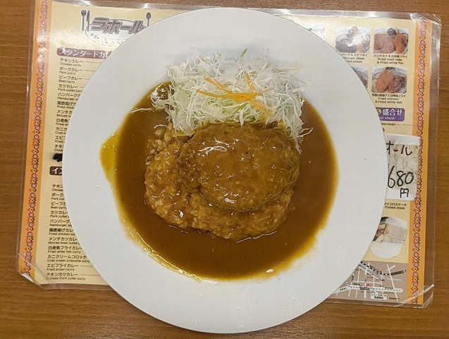 『ニューラホール 本所吾妻橋店』の「ハンバーグカレー」（半ライス）でランチ。 このハンバーグは決して上等なハンバーグの味はしない。  この味は、あたしのような昭和30年代生まれにとってはたまらないものがある。つまり、 うまいのであるな（笑）。（ニューラホール 本所吾妻橋店：墨田区吾妻橋3丁目）
