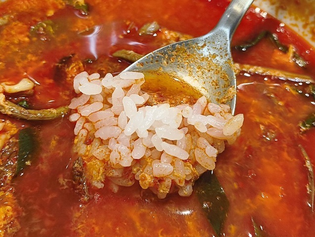 スプーンにとったご飯をスープに浸す