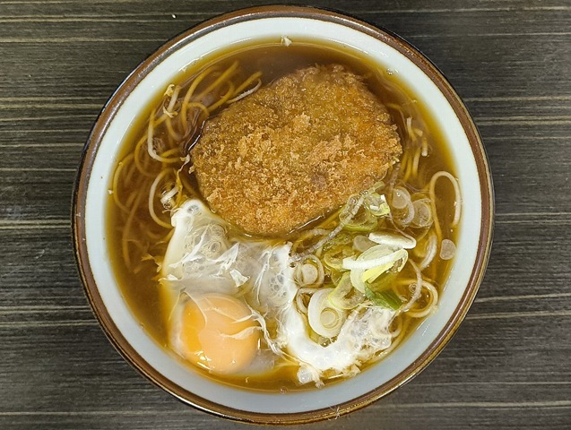 「文殊 浅草店」で「コロッケそば」+「生たまご」でランチ。「コロッケ」の部類では最低の物だろうが、 これが汁を吸い、その姿を崩すころ、抜群のうまさを発揮するのは言うを待たないのだ。うまいのだよ（笑）。（文殊浅草店：浅草一丁目：浅草地下街）