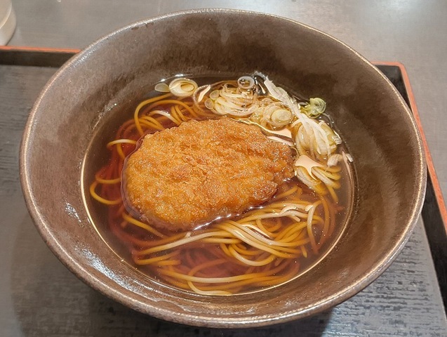 コロッケをかけそばに入れてやる