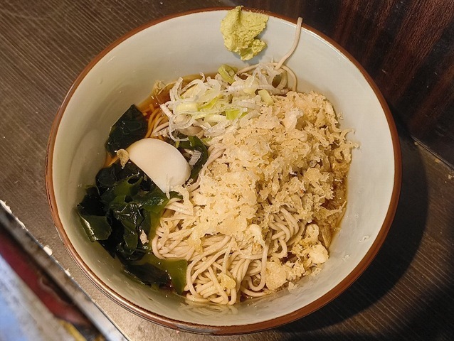 「文殊」の「冷やしたぬきそば」でランチ。これは「天かす」が決め手で、それはひたすら辛い「汁」と「天かす」の黄金の出会いにある。 出会った途端に「天かす」の油が「蕎麦」全体をコーティングし始めるのだ。うまいのだよ。（文殊 浅草店：浅草一丁目：浅草地下街）