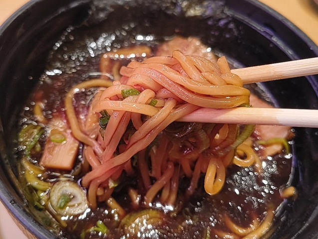 真っ黒く染まった麺を食べる