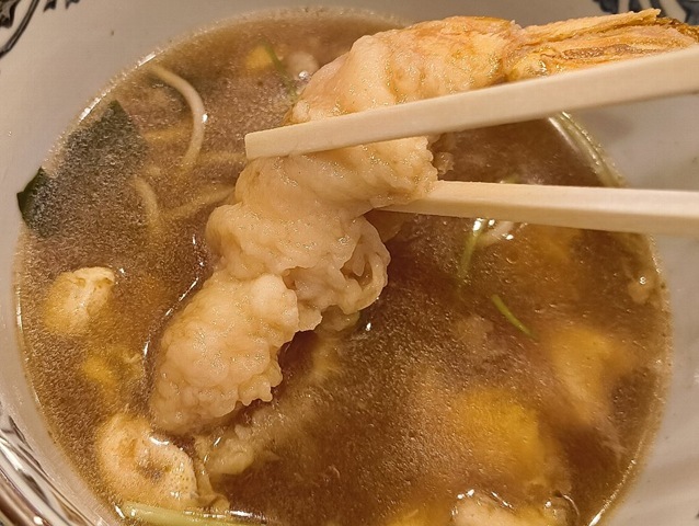 充分に汁を吸った海老天に箸を入れる