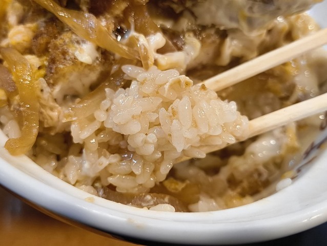 汁の染み込んだご飯を食べる