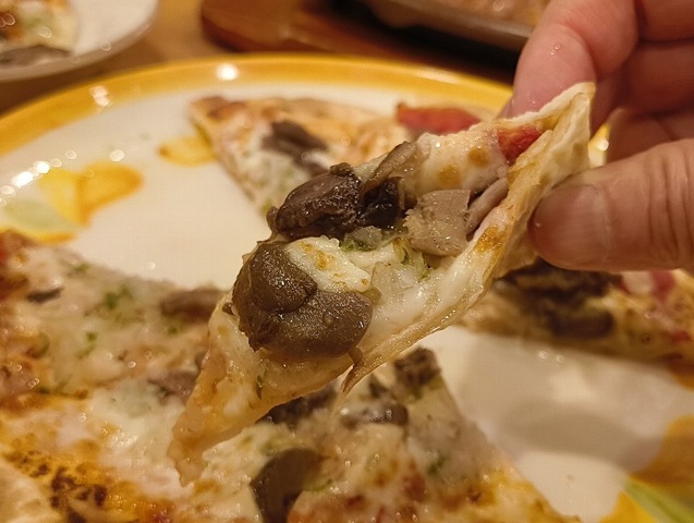 野菜ときのこのピザを食べる