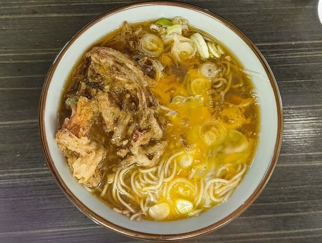蕎麦丼の表面を黄色いたまごと茶色のかき揚げが二分する