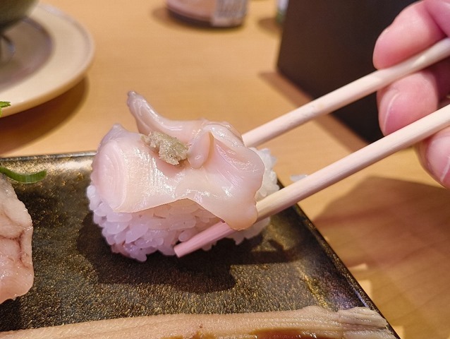 つぶ貝にわさびをのせて食べる