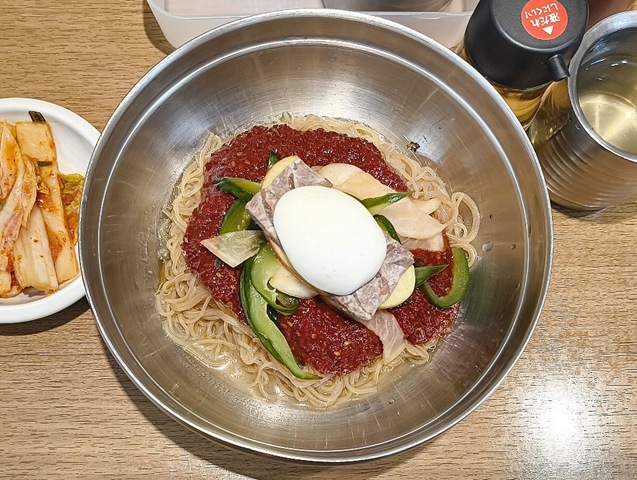 『妻家房 松屋浅草店』の「ビビン冷麺」でランチ。まずはしっかりと麺をかき混ぜる。 赤く染まった麺を口に運ぶ。 店のメニューには唐辛子2本のマークがついているが、辛いがその奥にはしっかり甘みも同居していたりする。 うまいのだよ（笑）。（妻家房 松屋浅草店：花川戸一丁目）