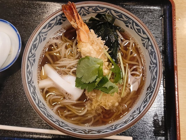 「琴富貴」の「天ぷらそば」（並）でランチ。「海老天」は枕にするものもなく、ただ尻尾だけが丼の縁まで伸びている。 濃い緑の「わかめ」は「海老天」の敷き布団と化し、「三つ葉」がちょっとした掛け布団のようだ。 勿論、うまいのだよ（笑）。（琴富貴：墨田区吾妻橋1）