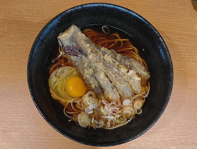 改装なった『文殊 浅草店』で「ナス大天そば」と「生たまご」でランチ。「生たまご」を「ナス大天」の無い片側に広げれば、ナスの「濃紺」と黄身が見事なコントラストを描き出す。そして たまごを纏った蕎麦をズルズルと手繰れば、いやはや、もう堪らない。 うまいのだよ（笑）。（文殊 浅草店：浅草一丁目：浅草地下街）