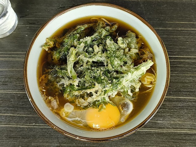 「文殊」で「春菊天そば」＋「生たまご」でランチにしたこと。 今日の「春菊天」は何時もより細切れ具合が甘いし、「春菊天」の盛り方も一端を丼にかけるのではなく全面を汁に浸してある。 だからと云ってまずいわけではないのであるな、それはうまいローテーションの始まりなのだよ（笑）。（文殊 浅草店：浅草一丁目：浅草地下街）