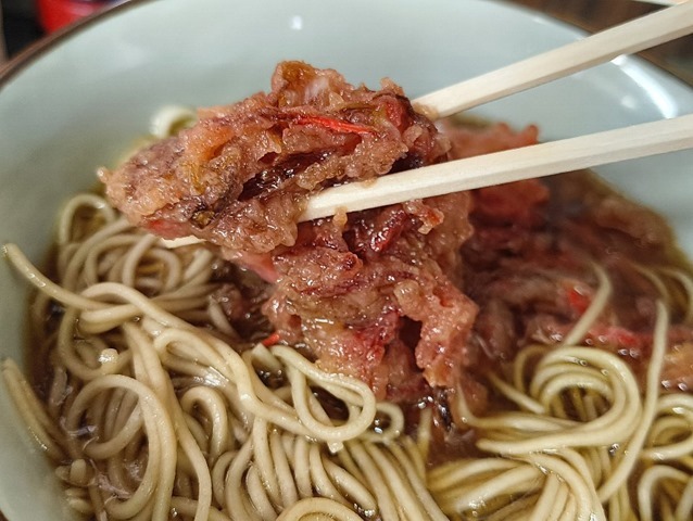 そばらばらになる寸前の紅ショウガ天を食べる
