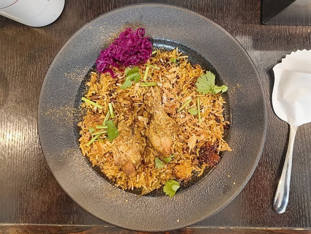 『スパイススペースウガヤ』の「チキンビリヤニ」でランチ。チキンが2本置かれ、パクチーがパラパラと散らされている。 よく見ると、わけのわからないスパイス達が、ふりかけのように散在している。 そして、「おこげ」の存在.。そのうまさは益々複雑さを増していたのだよ（笑）。（スパイススペースウガヤ 松屋浅草店：花川戸1丁目：松屋浅草 B1F）