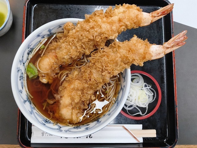 「尾張屋 支店（雷門店）」の「天ぷらそば」でランチ。大きな「海老天」の先を「汁」に泳がせながら、先ずは「蕎麦」を手繰ってみる。さらに「海老天」を食べるのだが、 その様相は正に「天ぷらそば」はこうあるべき、という「ふにゃふにゃ」になった姿なのだ。うまいのだよ（笑）。（浅草一丁目）