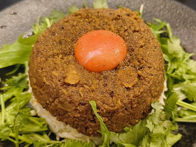 パンパンに固められたライス、その上のカレー、そして頂点の黄身