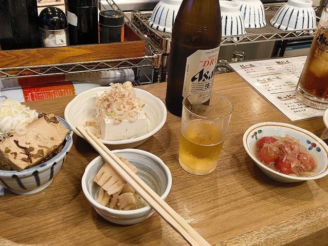 牛すじ煮込みと冷奴と瓶ビールとお通しとトマトのマリネ