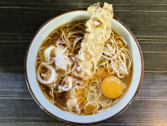 「文殊」で「ちくわ天そば」＋「生たまご」でランチ。「ちくわ天」の「衣」が徐々に汁を含んでゆくと同時に油が染み出してゆく。 その油の浮いた「汁」を徐に「蕎麦」と混ぜ合わせて手繰れば「蕎麦」が益々うまくなっている、最高だ（笑）。（文殊 浅草店：浅草一丁目：浅草地下街）