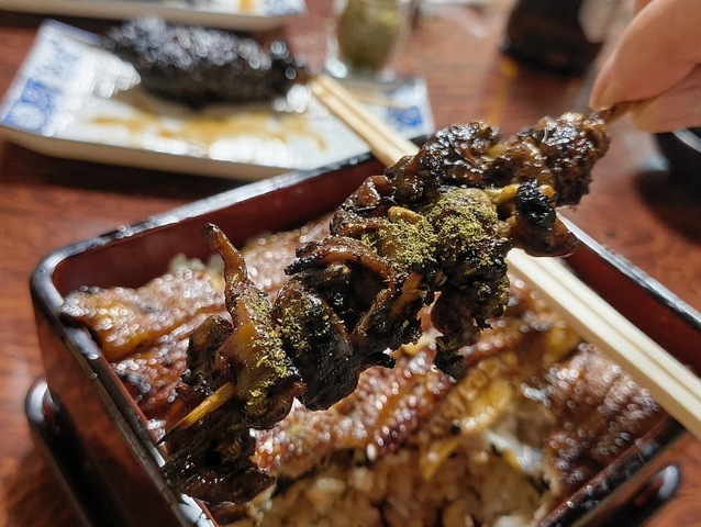 山椒をたっぷりと振り掛けてきも焼きを食べる