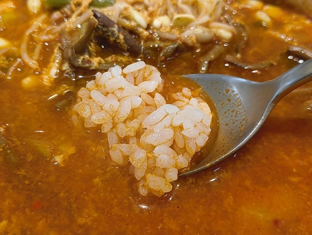 スプーンにとったご飯をスープに浸す