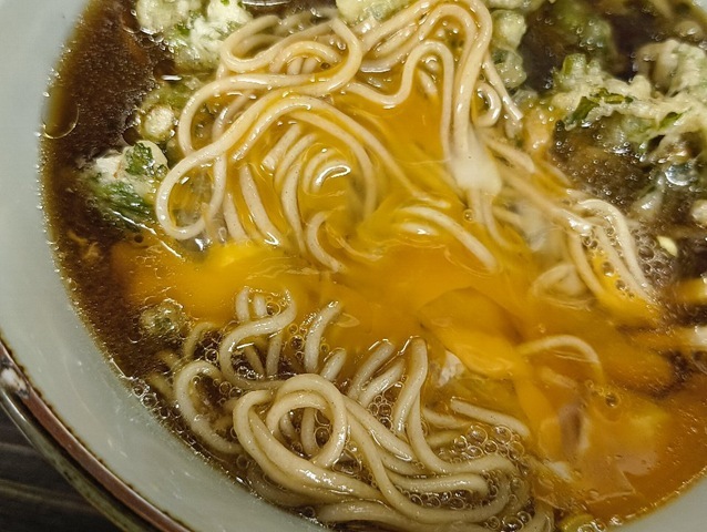 玉子の黄身を蕎麦の上に散らして一手繰り