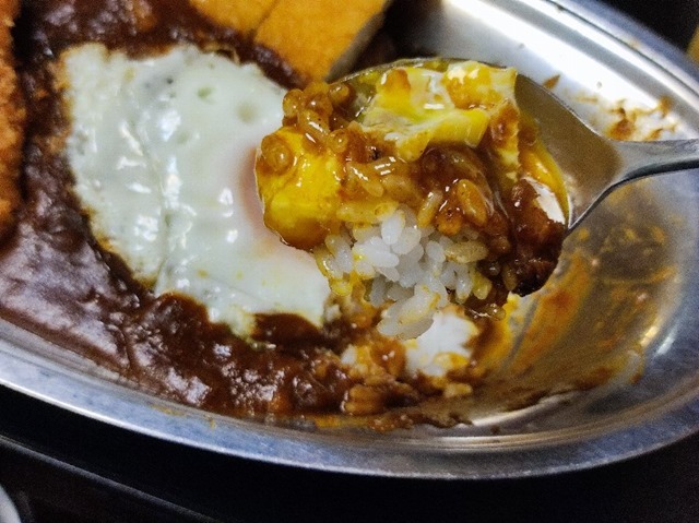 目玉焼きの黄身とカレーを食べる