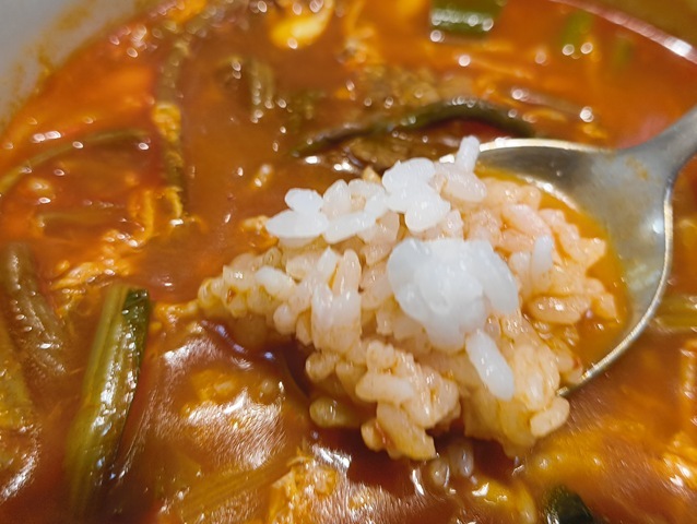 スプーンでとったご飯をスープに浸した