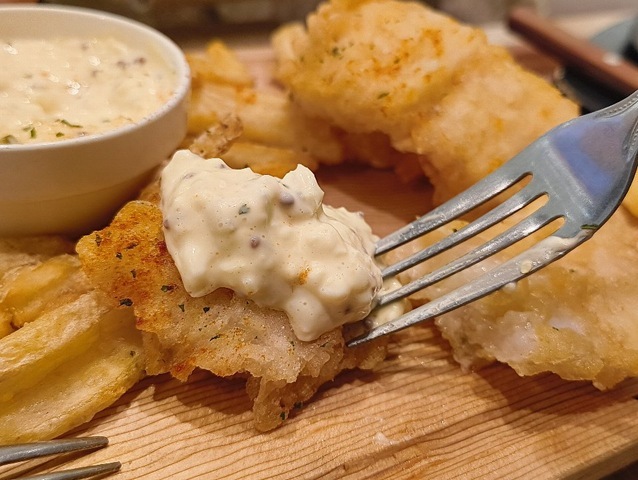 タルタルソースで白身魚のフライを食べる